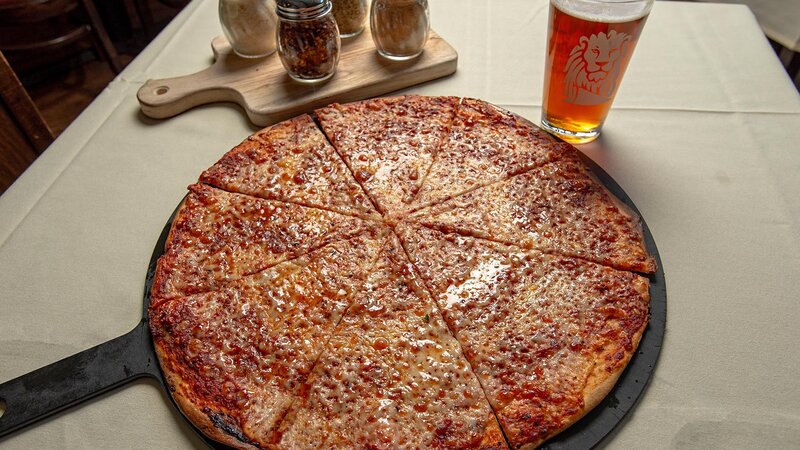 Pizza pie with pint of beer