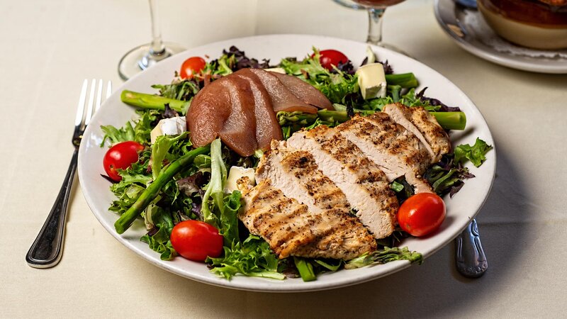 Grilled chicken on a bed of salad with pears and tomatoes